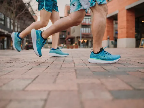 A pair of runners in ASICS Gel-Cumulus 25, showing off one of the best sustainable running shoes.