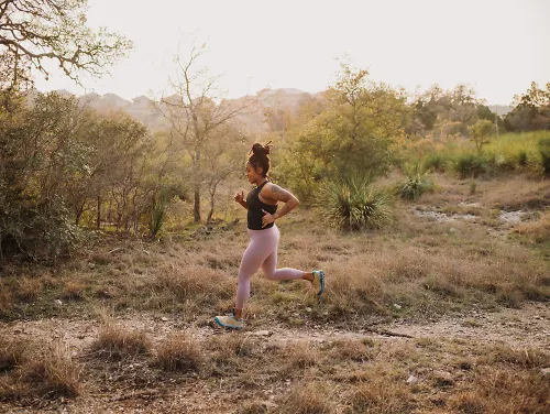 A woman runs solo along a trail.