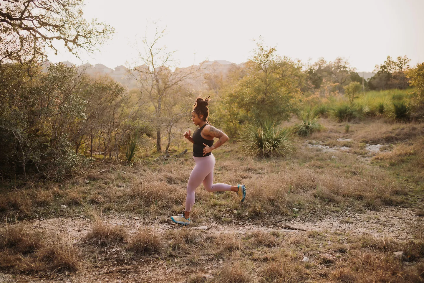 A woman runs solo along a trail.