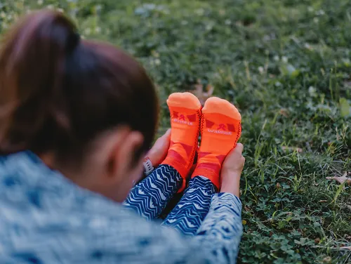 A woman stretches in her Balega running socks. 