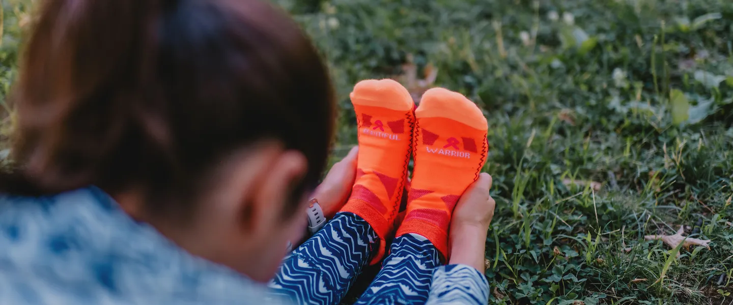 A woman stretches in her Balega running socks. 