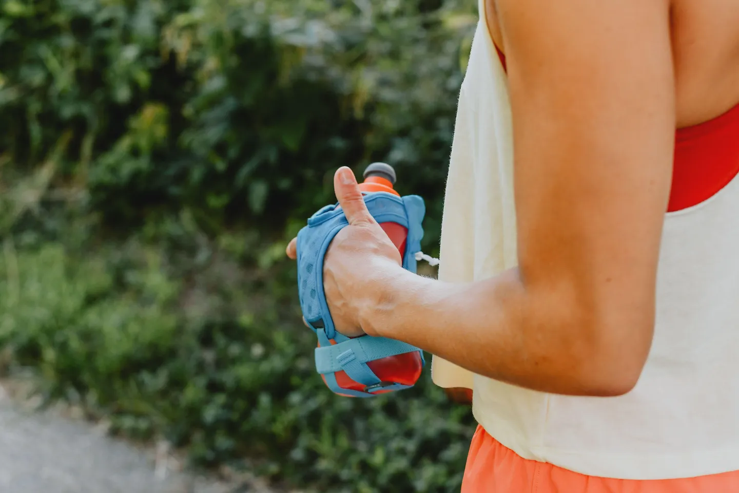 A runner holds a handheld water bottle.
