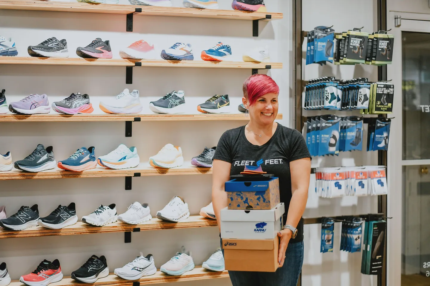 A Fleet Feet outfitter holds several boxes of running shoes.