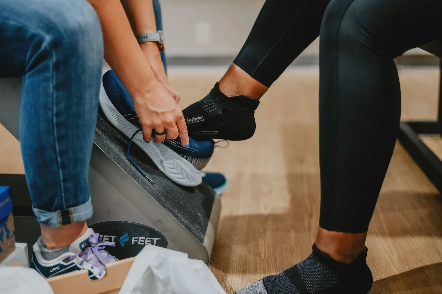A customer slides into a pair of shoes while wearing Feetures socks.
