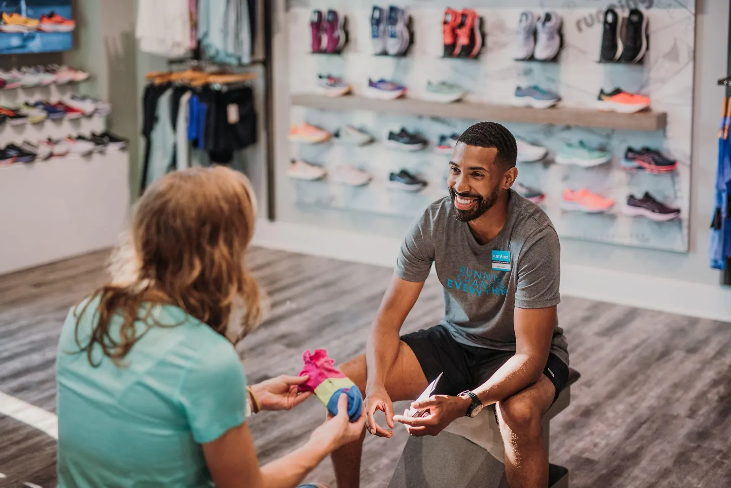 A customer tries on a pair of Feetures socks at Fleet Feet.