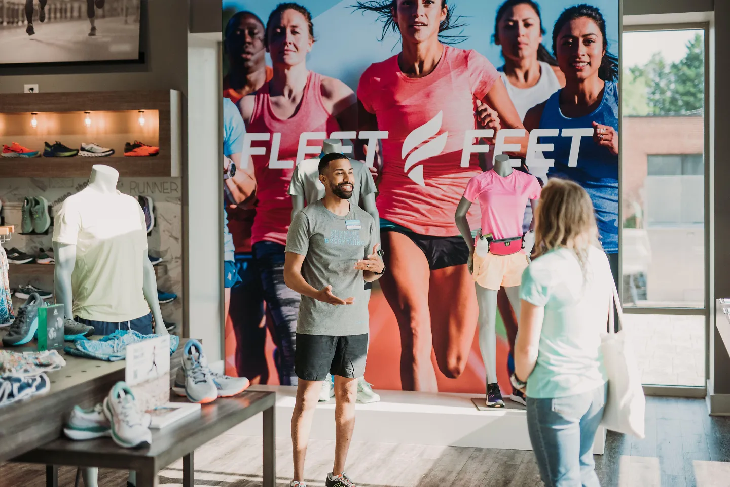 A Fleet Feet employee greets a customer in the store