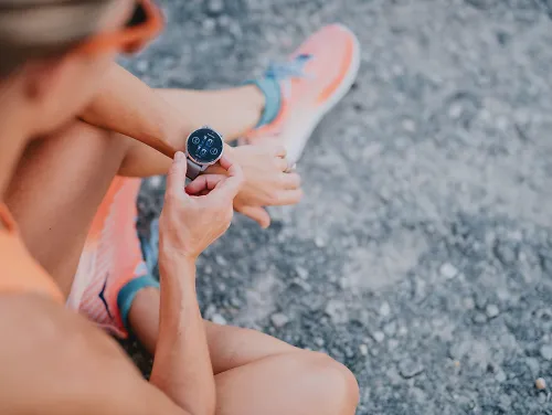 A woman gets her Garmin watch ready for her run workout.