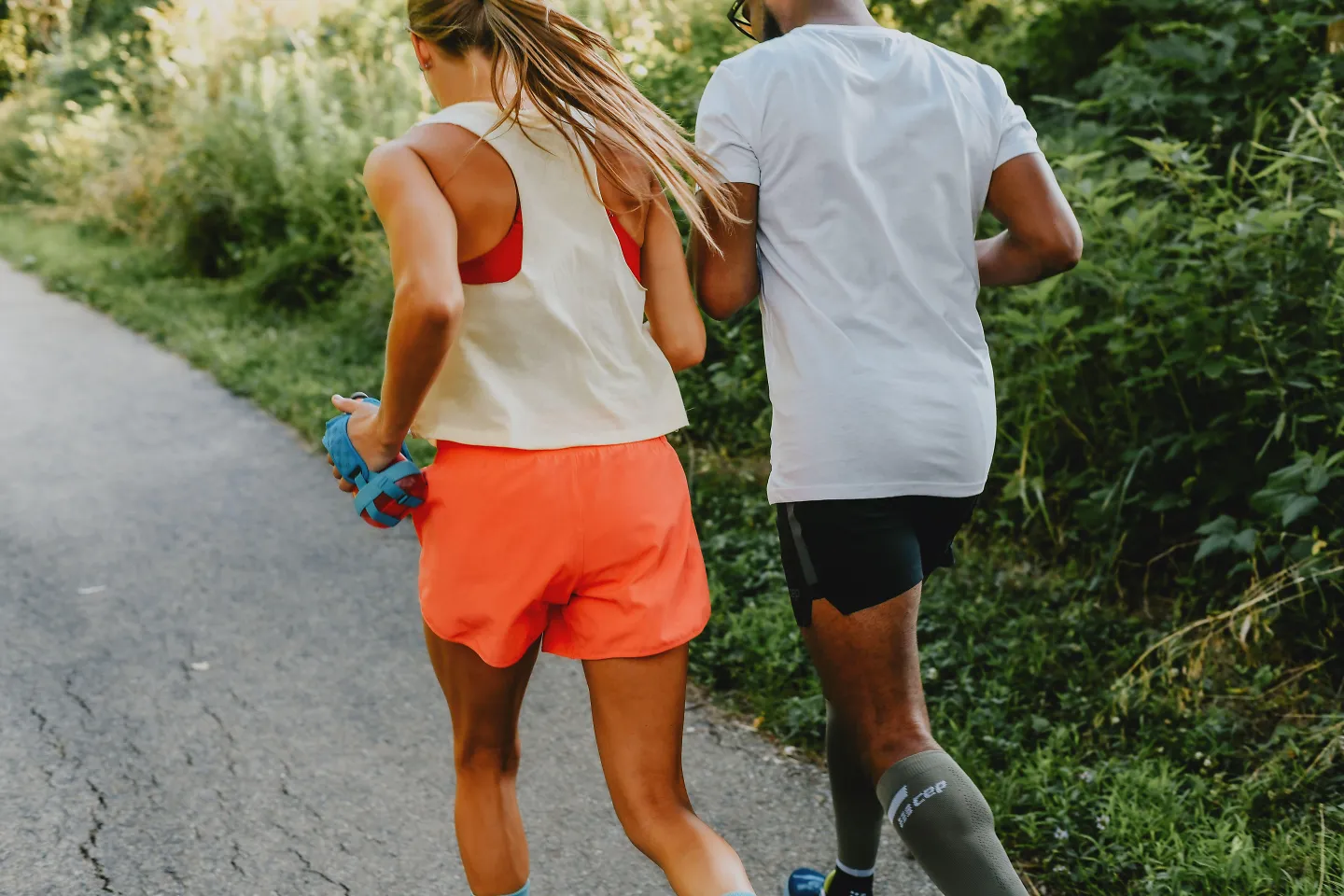 From the back, a man and woman run side by side.
