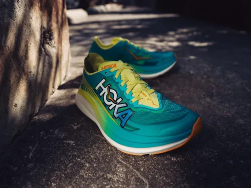 The HOKA Rocket X 2 sits on the concrete ground. 