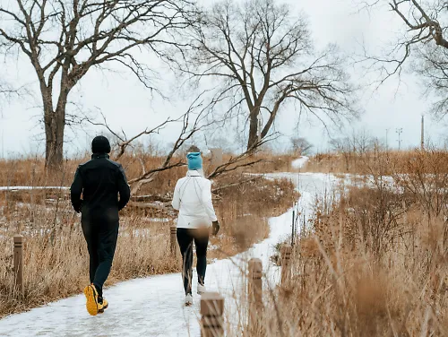 Runners run in cold weather dressed in many layers.