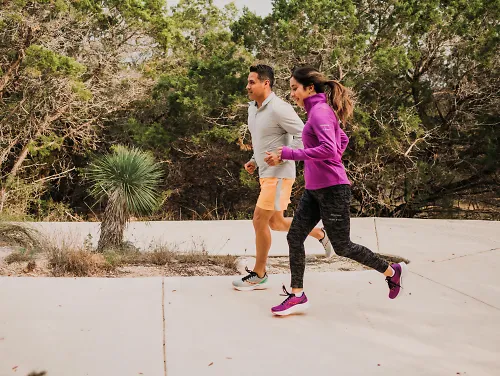 Two runners run together.
