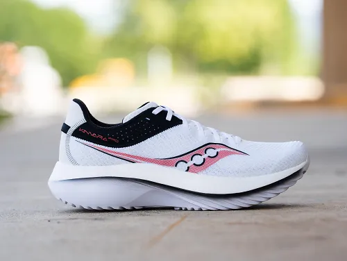 The white Saucony Kinvara Pro sits on the pavement.