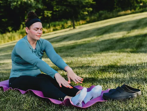 A woman stretches on a yoga mat.