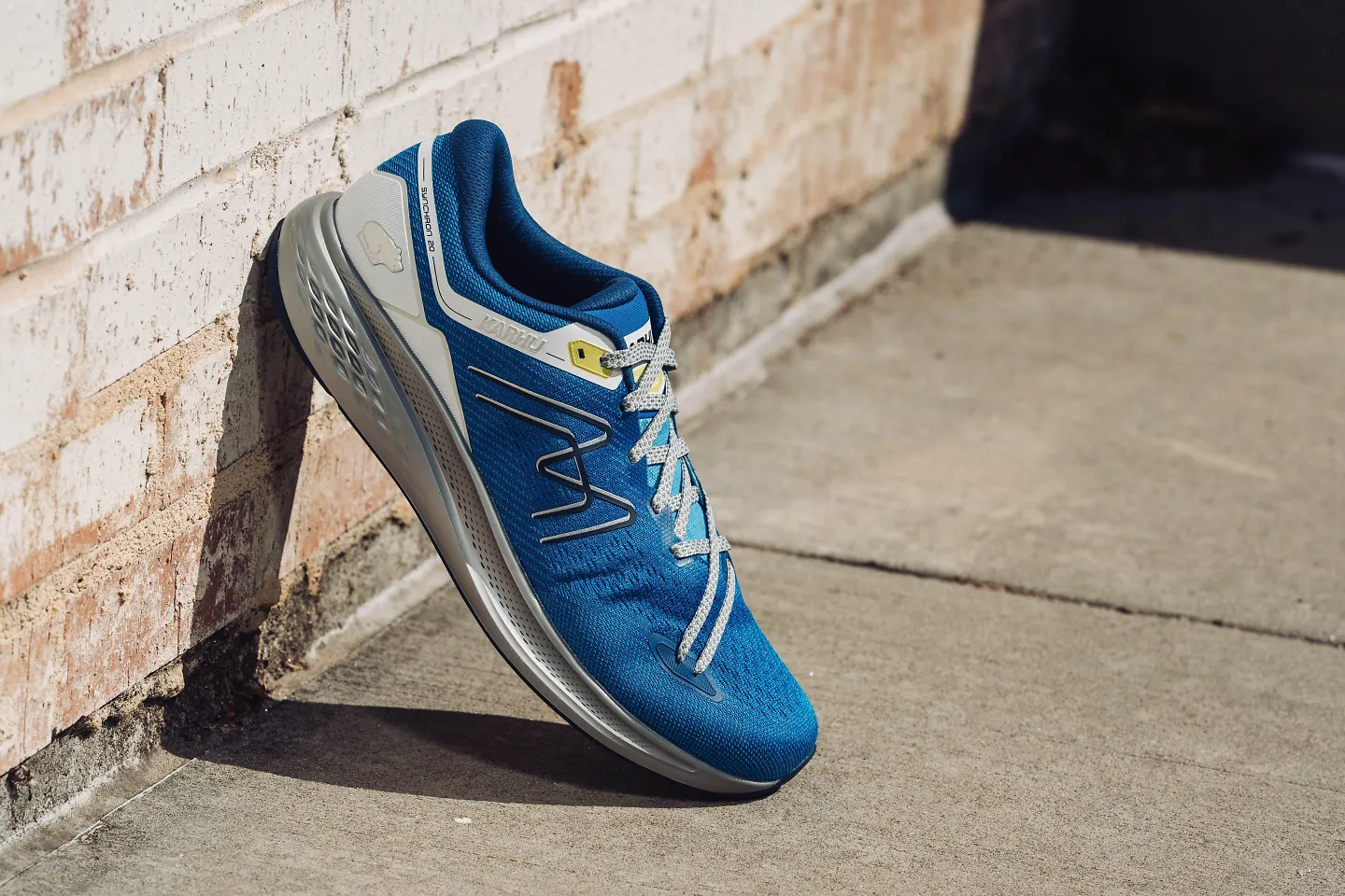 A men's Karhu Synchron sits propped up against a wall.