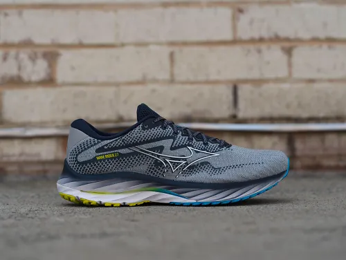 The men's Mizuno Wave Rider 27 sits sideways on the ground.