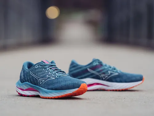 A pair of the women's Mizuno Wave Inspire 19 sits on a concrete slab. 