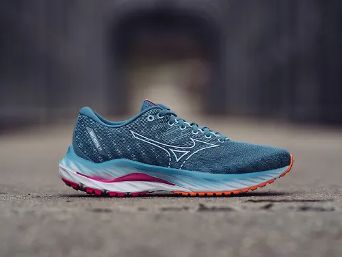 The women's Mizuno Wave Inspire 19 sits on a concrete road.
