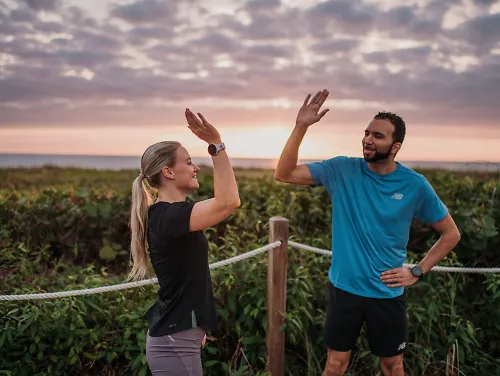 Runners high five after completing a run.