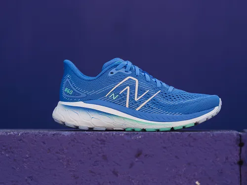 A pair of the New Balance women's 860 sits on a slab of concrete.