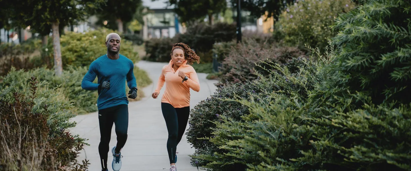 Runners run down a sidewalk.