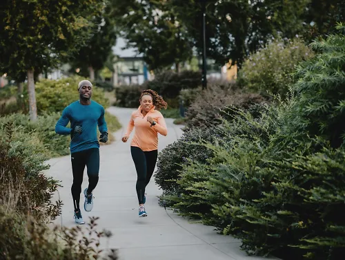 Runners run down a sidewalk.