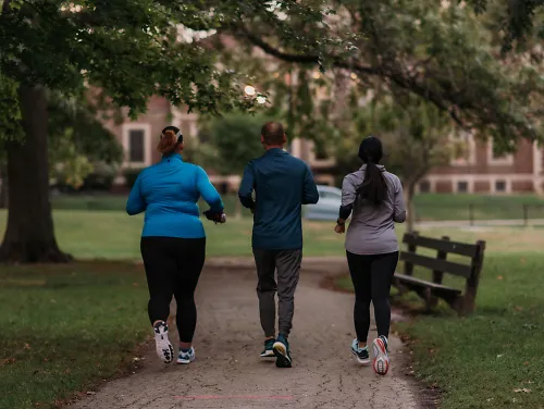 Three runners run together down a path.