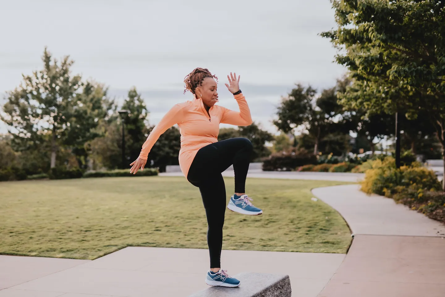 A woman gets ready to run in a public park.