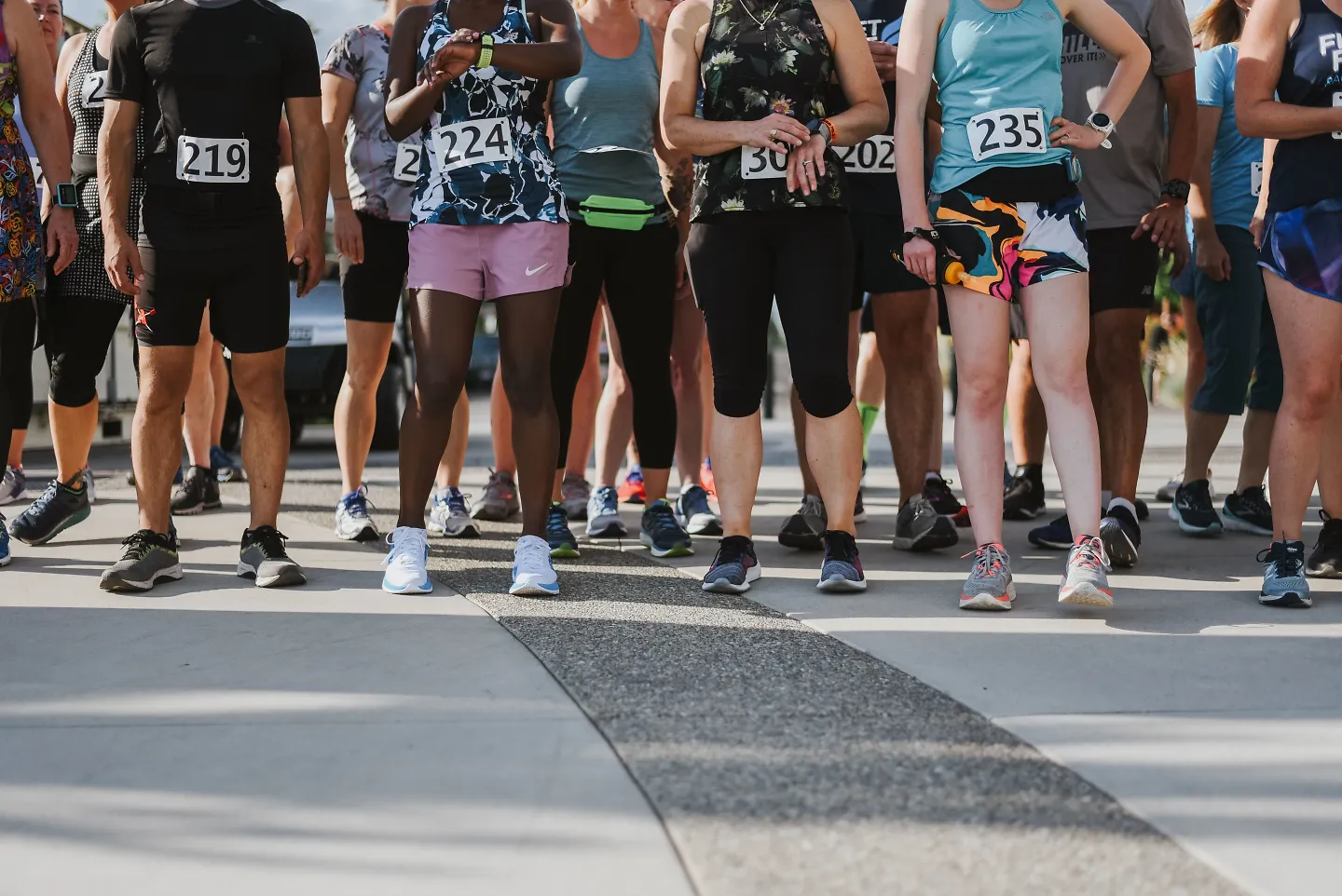 Runners stand on the start line of a race.