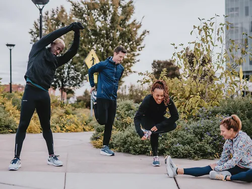 A group of runners stretch after their run. 