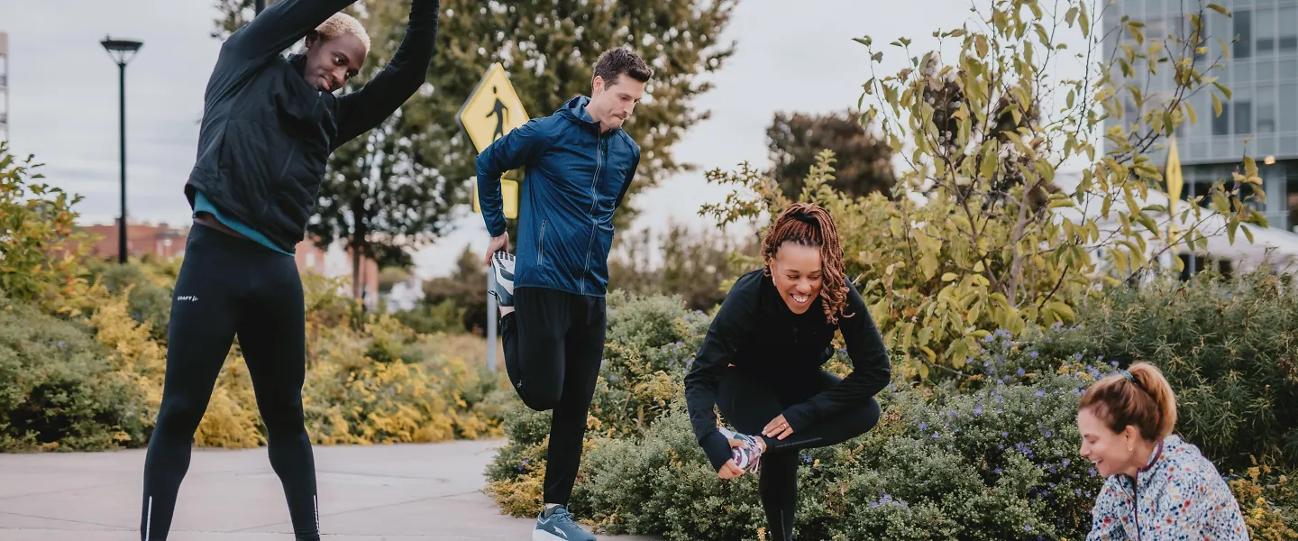 A group of runners stretch after their run. 