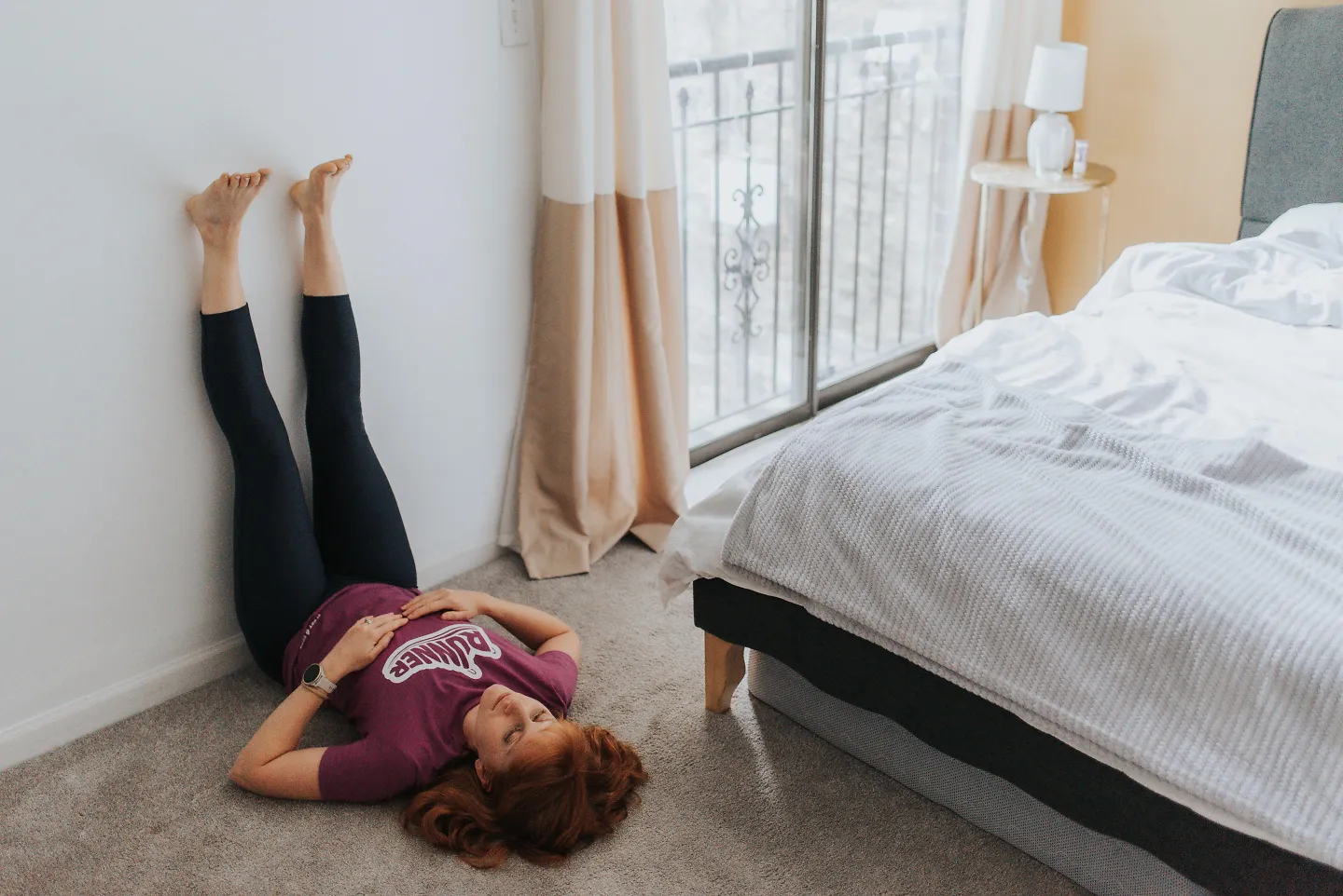 A woman props her legs up on the wall.