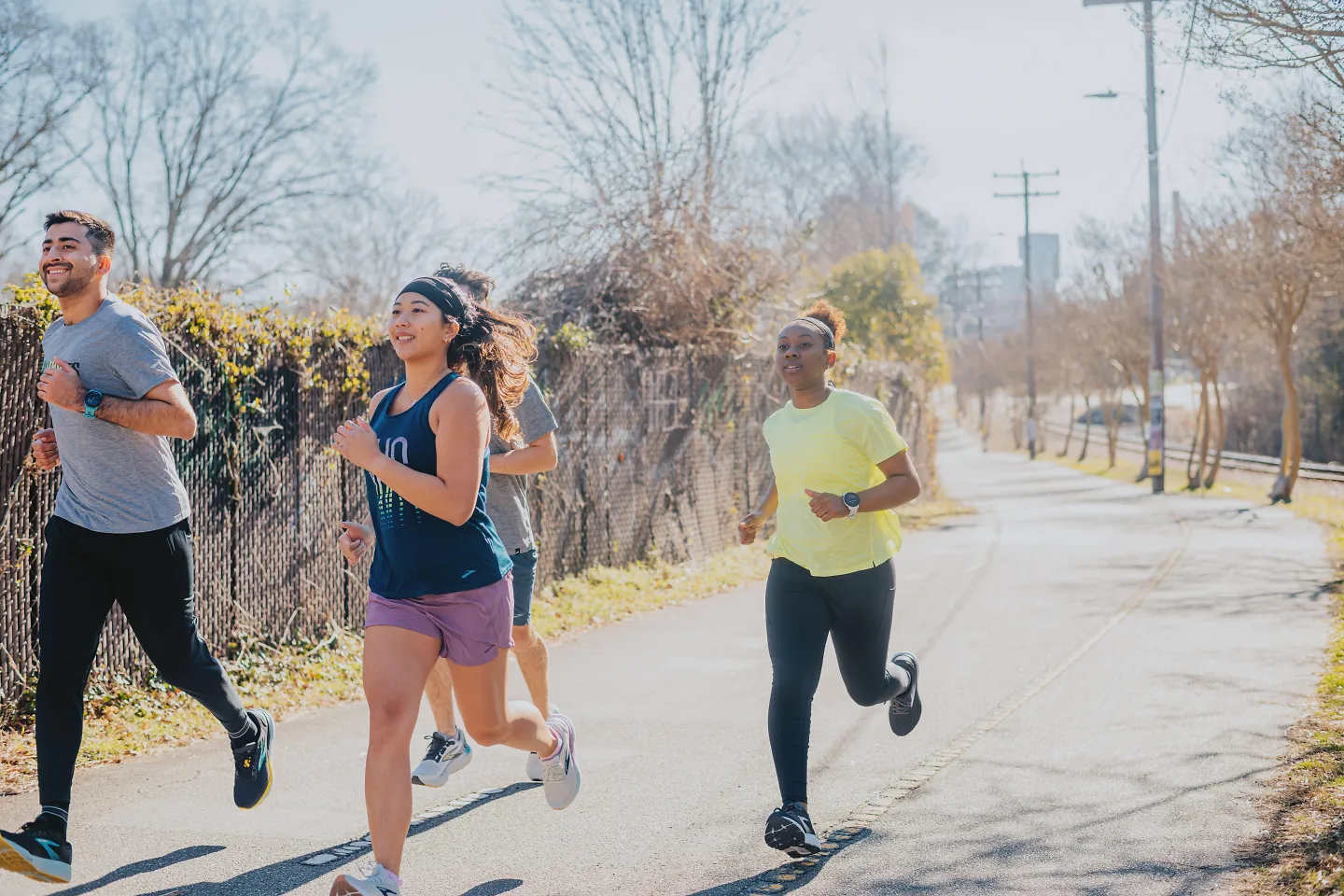 A group of runners run on a path.