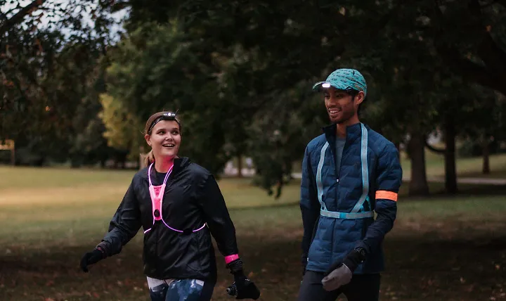 A man and woman walk through a park.