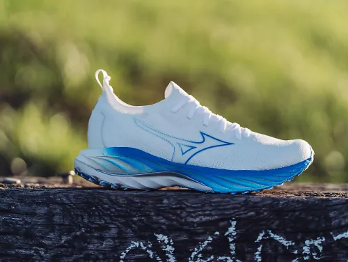 A pair of the Mizuno Wave Neo Wind sits against an outdoor backdrop.