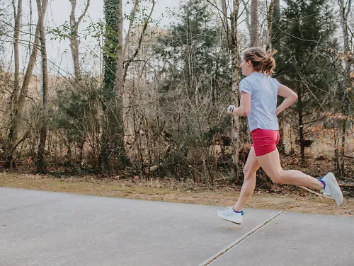 A woman runs on a greenway. 