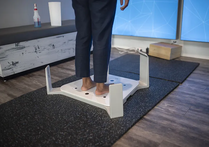 A Fleet Feet customer stands on a fit id scanner