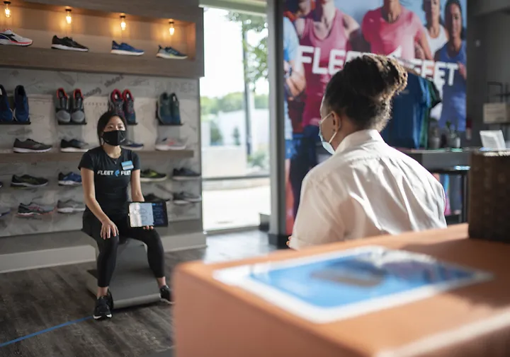 A Fleet Feet employee talks with a customer