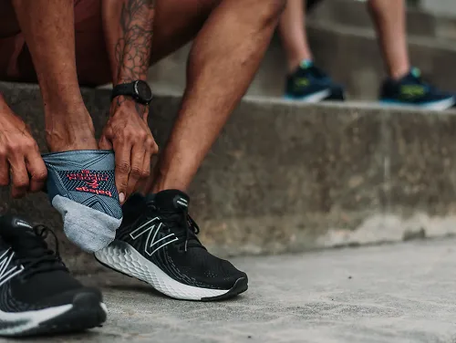 A runner slips on the New Balance 1080 before a workout