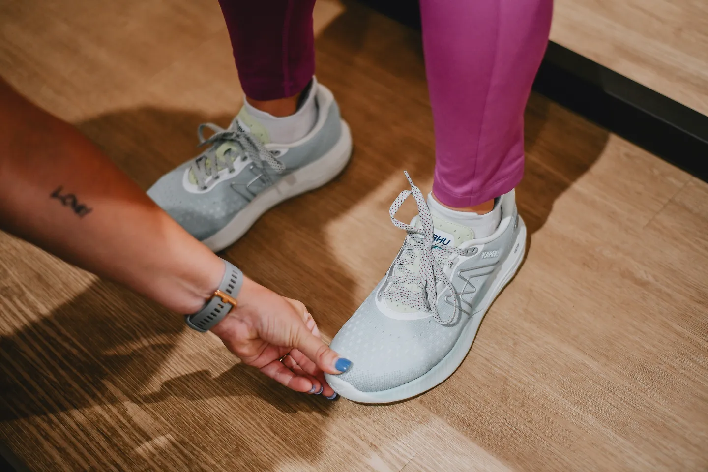 An outfitter checks a customer's foot to make sure the running shoes fit properly.