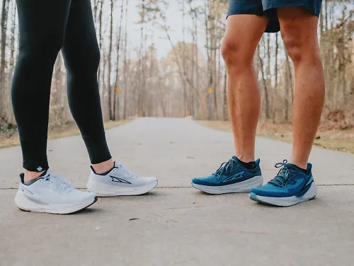 Two runners stand next to each other.