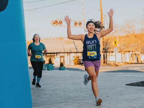 A runner celebrates as she crosses The Big Run finish line