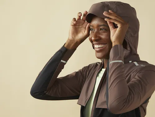 A woman in a On Weather Jacket with the hood up