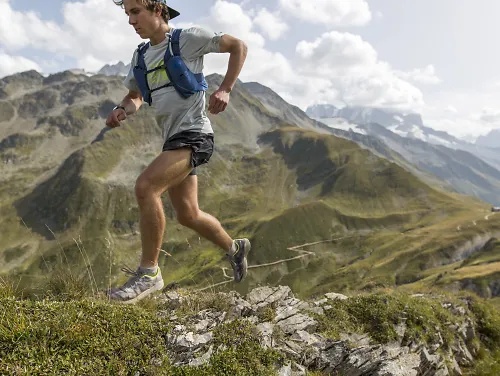 Man running in the mountains with a hydration vest