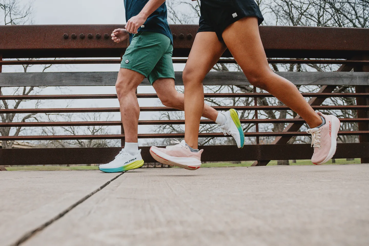 The Altra Experience Flow 2 being worn by two people running outside.. 
