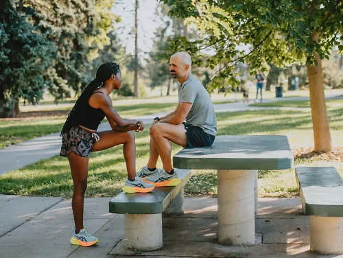 A man and woman chat before a run. 