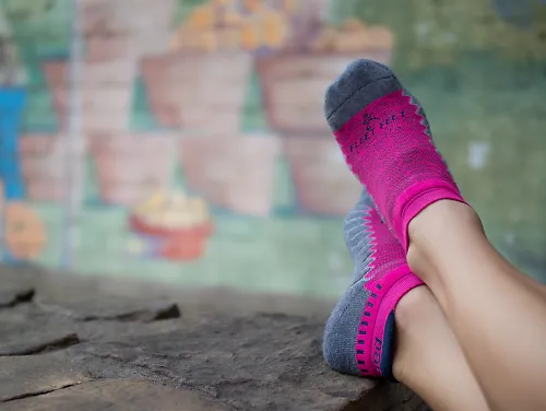 Person wearing pink Balega socks enjoying one of the best running books.