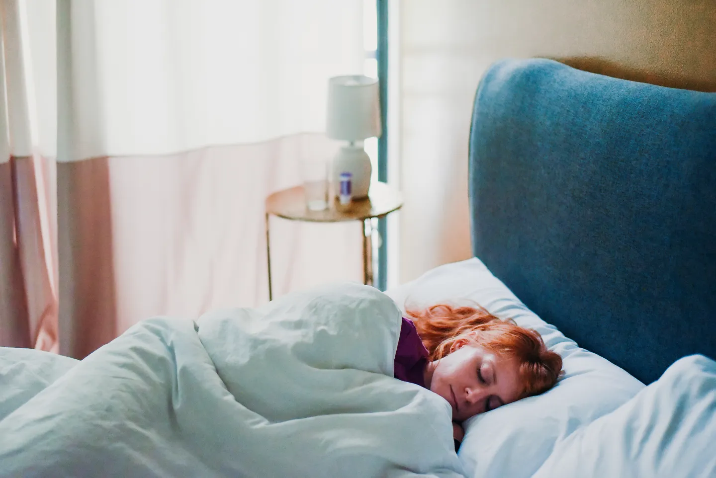 A woman sleeps in bed.
