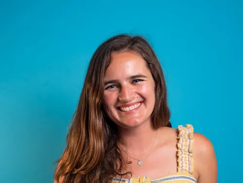 Taylor Dutch smiles in front of a blue background