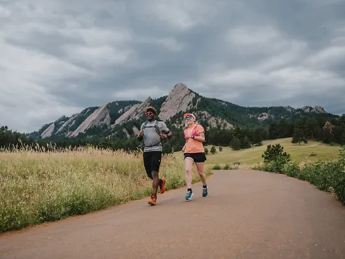 Two runners run through the mountains in Colorado, seemingly reaping the benefits of altitude training.