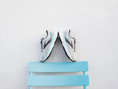A pair of Brooks Ghost 13s balanced on a bench